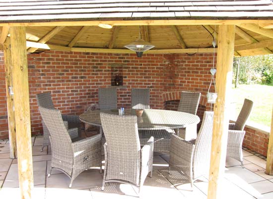 table and chairs inside open gazebo-style summerhouse